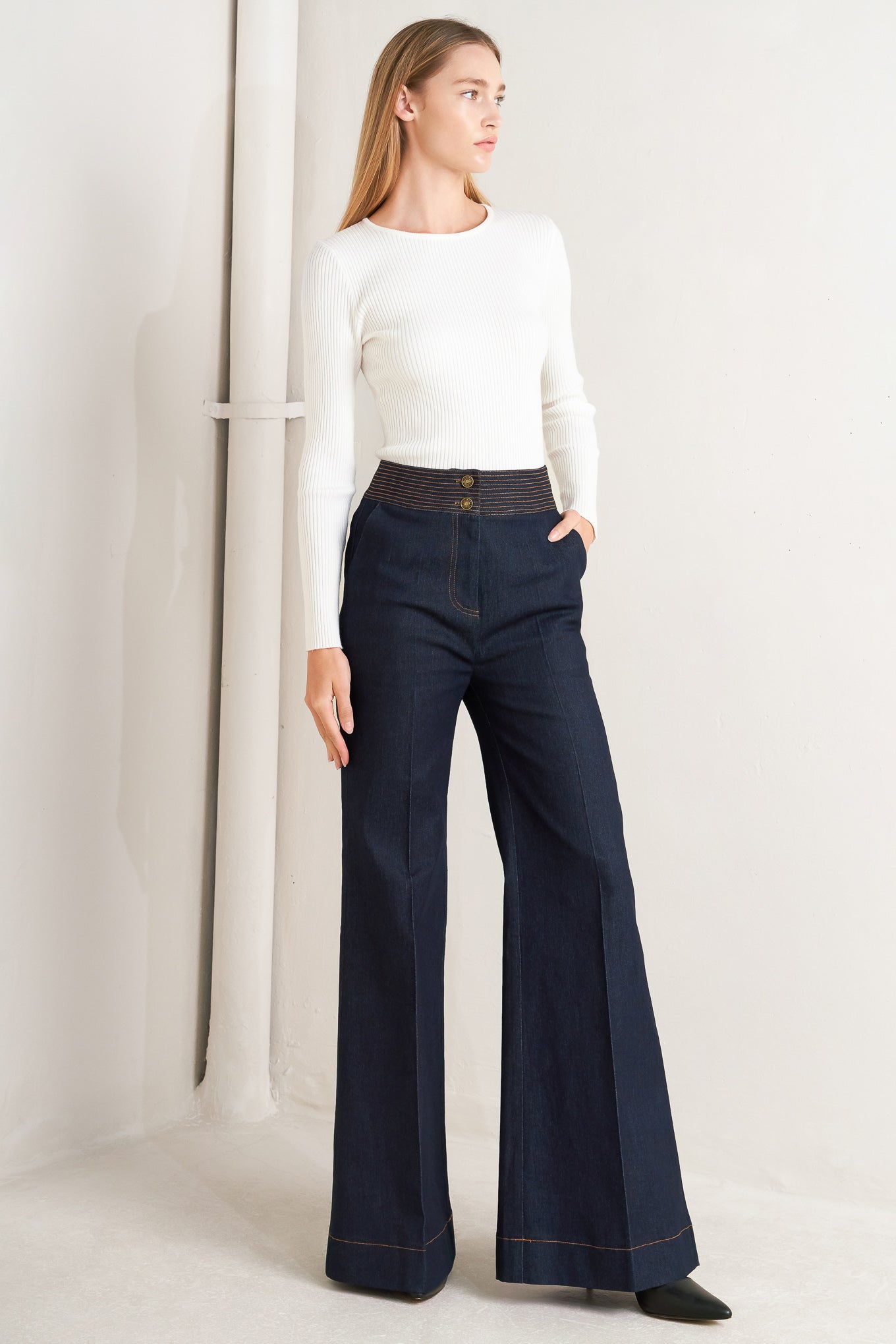 A denim pant featuring front closure, wide waistband with stitching detail, side pocket and wide leg.