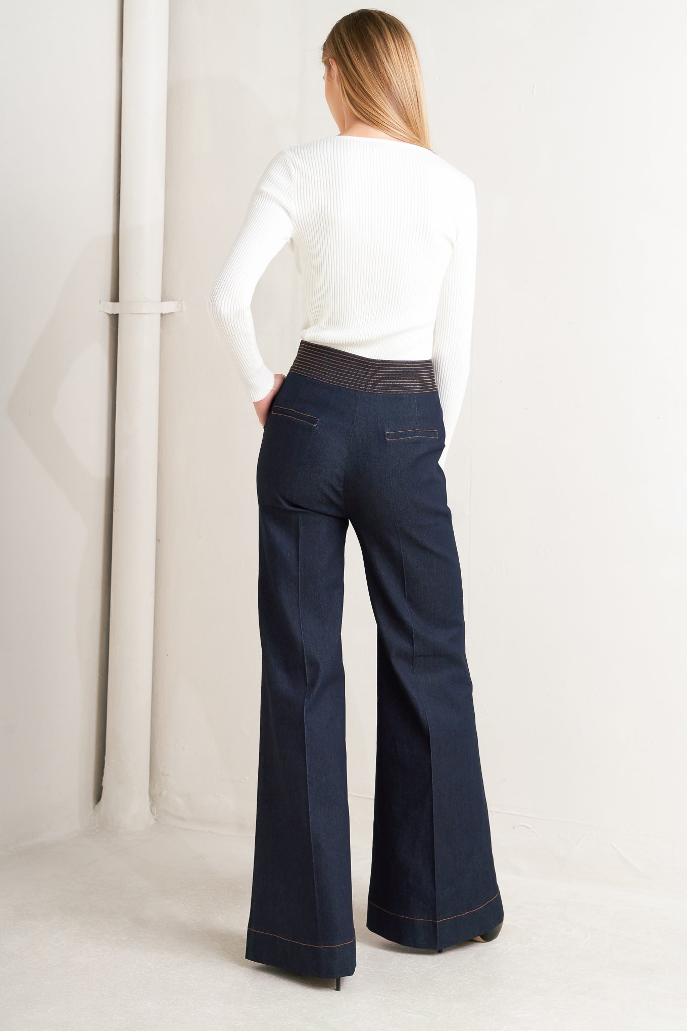 A denim pant featuring front closure, wide waistband with stitching detail, side pocket and wide leg.