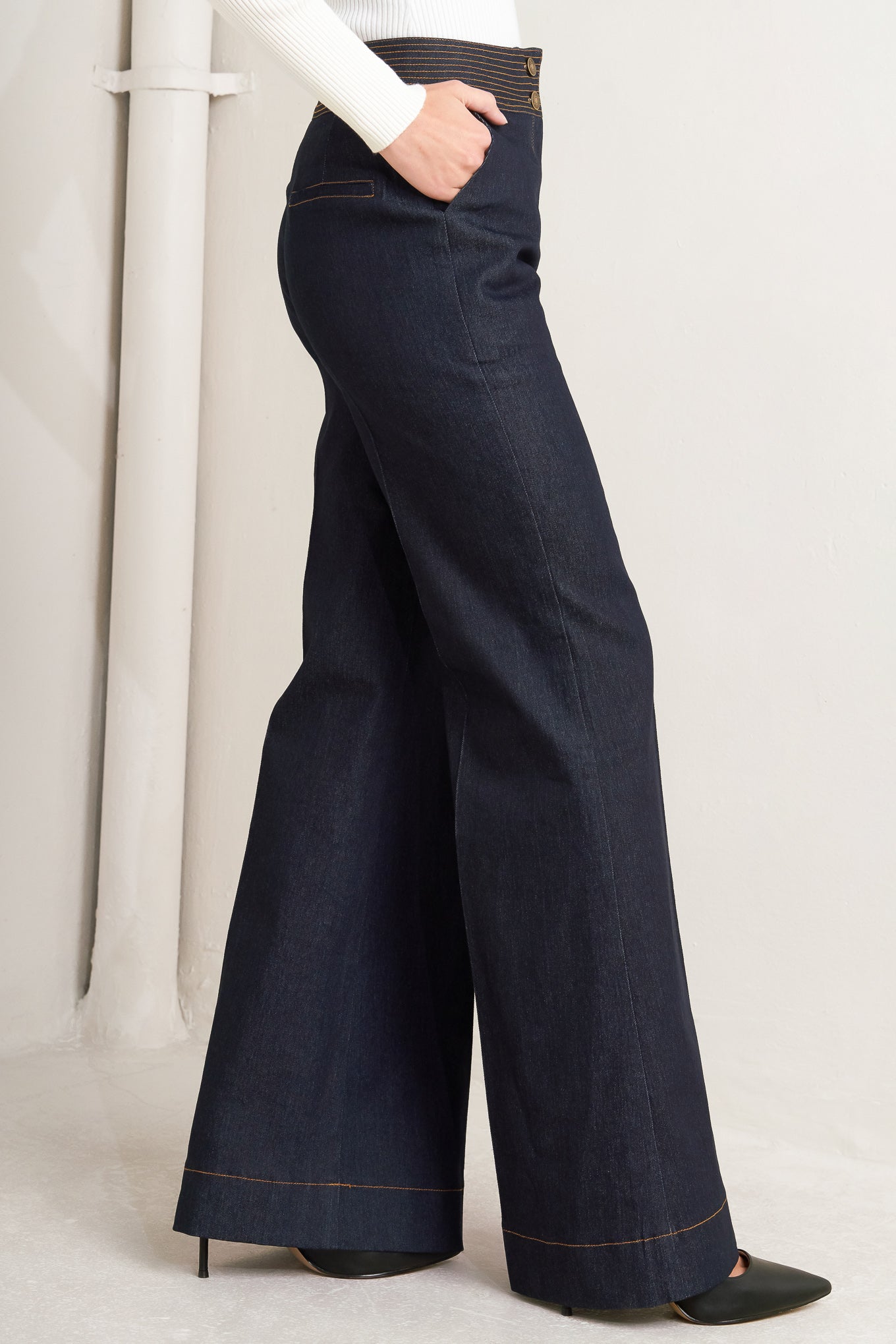 A denim pant featuring front closure, wide waistband with stitching detail, side pocket and wide leg.