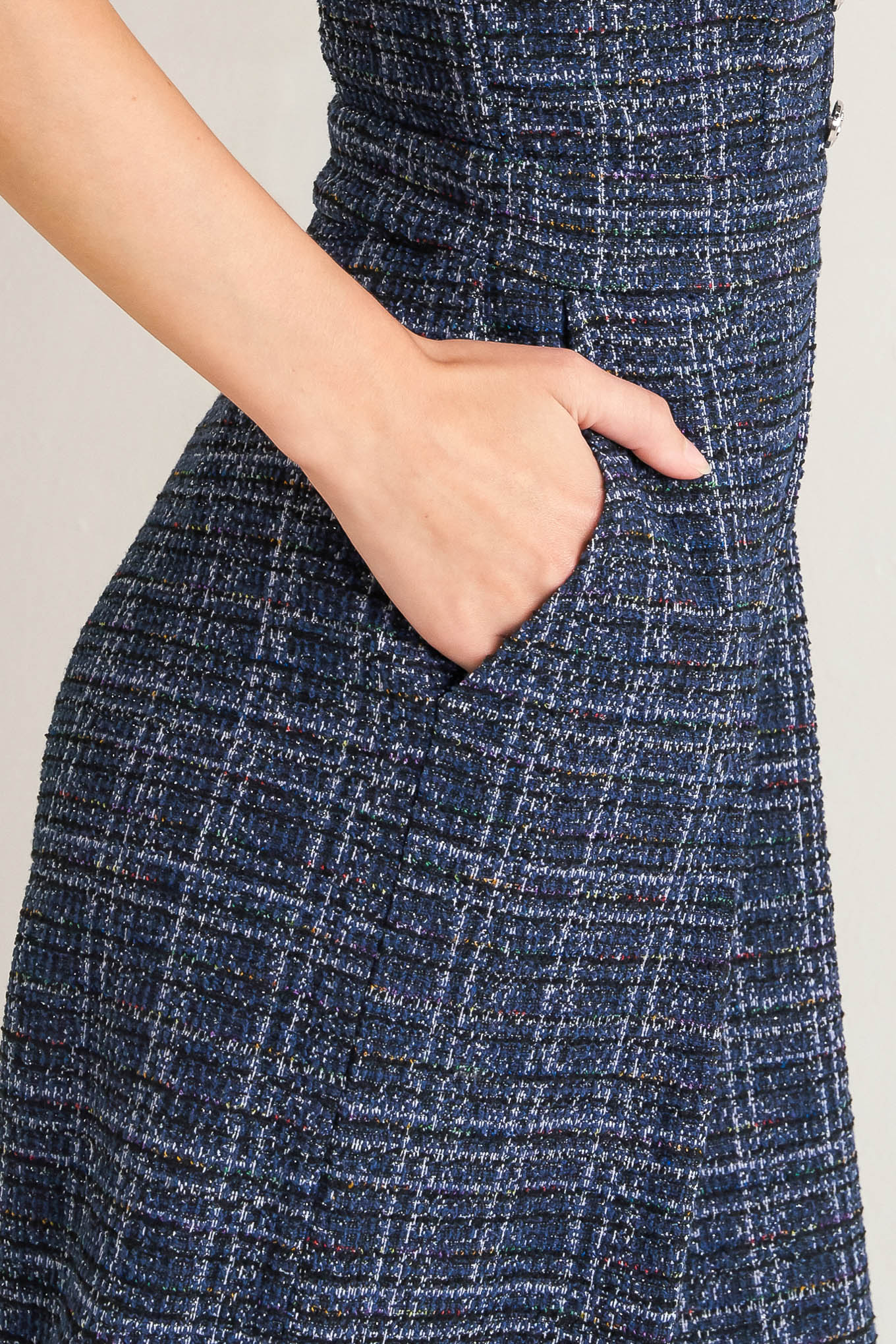 A tweed jumpsuit featuring sweetheart neckline, front button detail, side pockets and back zipper closure