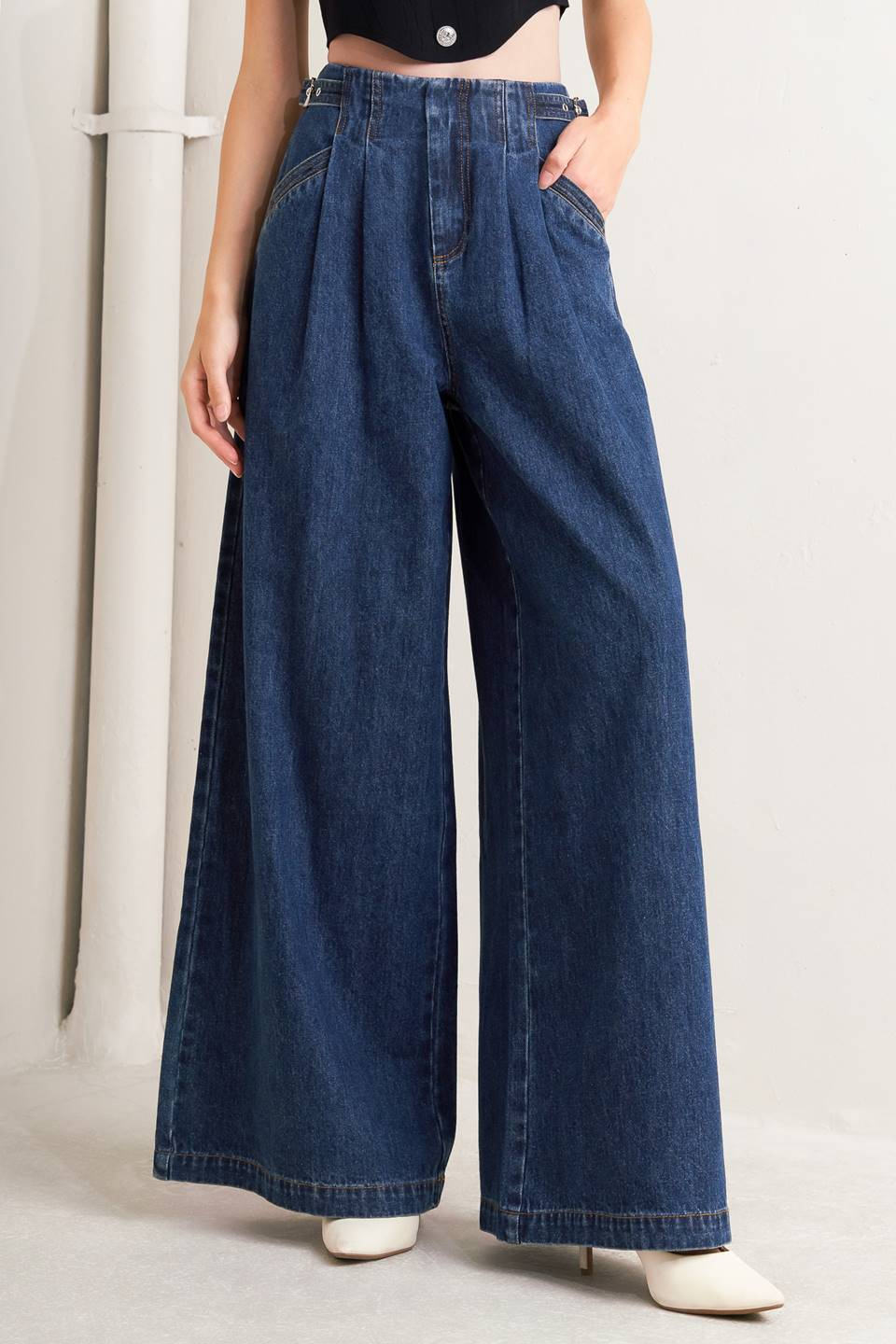 A denim pant featuring front closure, side buckle detail, pockets and wide leg.