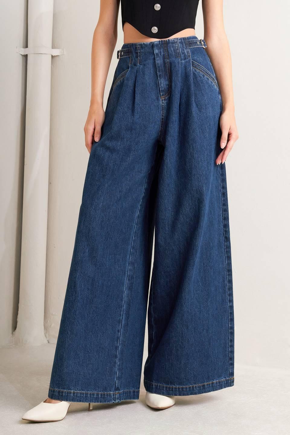 A denim pant featuring front closure, side buckle detail, pockets and wide leg.