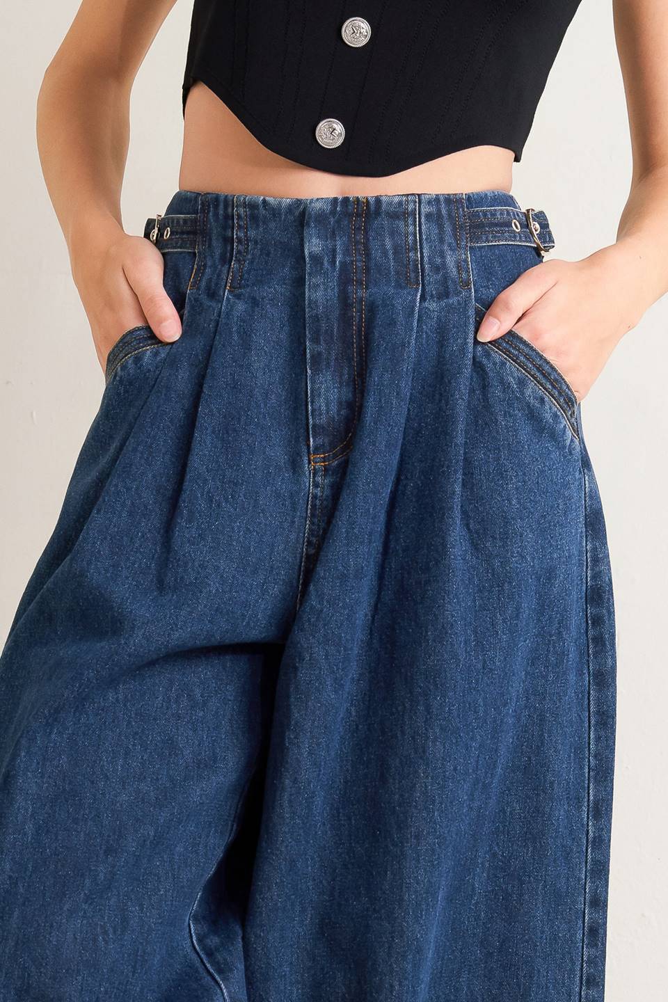 A denim pant featuring front closure, side buckle detail, pockets and wide leg.