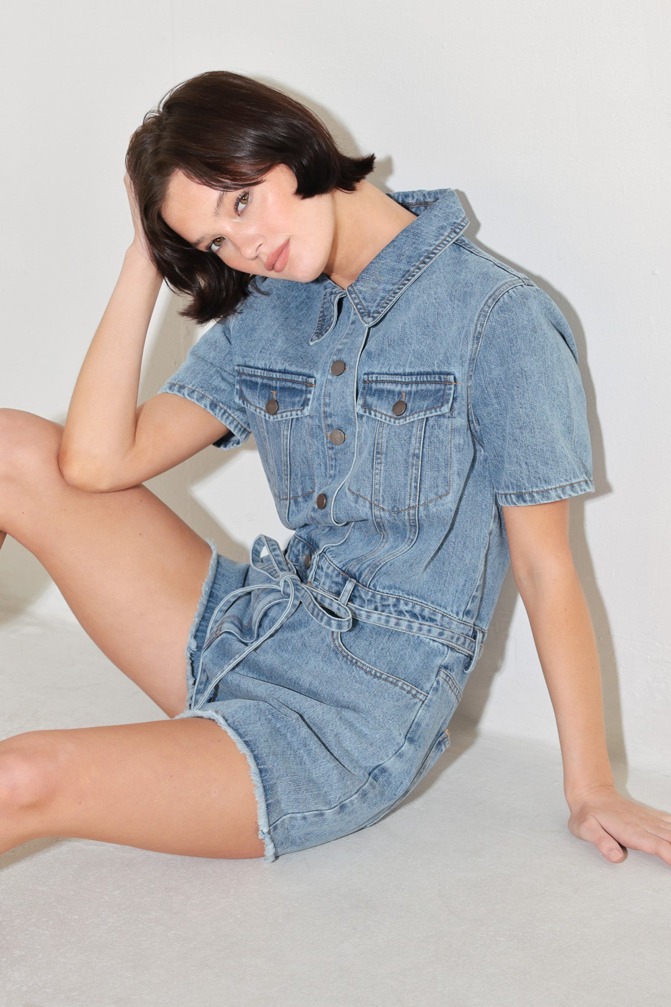 
A washed denim romper featuring collar, button down, short sleeve pockets and self tie

Details:

Self : 90% Cotton 10% Polyester

Size &amp; Fit

- Model is 5`8" And Wearing Size Small
- Measurements Taken From Size Small
- Approx. Length: 33"