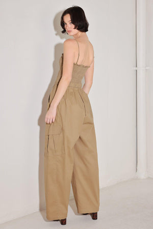 
A solid woven jumpsuit featuring straight neckline with ruffle edge, straps, smocked bodice, elastic waist with tie, pockets and wide leg

Details:

Self : 95% Cotton 5% Spandex

Size &amp; Fit

- Model is 5`8" And Wearing Size Small
- Measurements Taken From Size Small
- Approx. Length: 59"