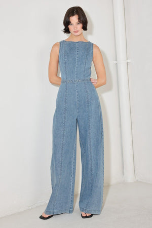 
A washed denim jumpsuit featuring wide neckline, sleeveless, self belt, wide leg and back zipper closure

Details:

Self : 90.2% Cotton 4.8% Viscose 5% Polyester

Size &amp; Fit

- Model is 5`8" And Wearing Size Small
- Measurements Taken From Size Small
- Approx. Length: 59"