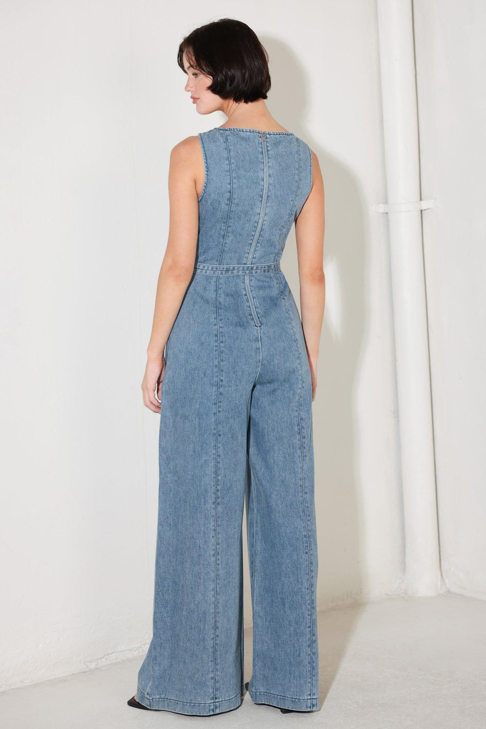
A washed denim jumpsuit featuring wide neckline, sleeveless, self belt, wide leg and back zipper closure

Details:

Self : 90.2% Cotton 4.8% Viscose 5% Polyester

Size &amp; Fit

- Model is 5`8" And Wearing Size Small
- Measurements Taken From Size Small
- Approx. Length: 59"