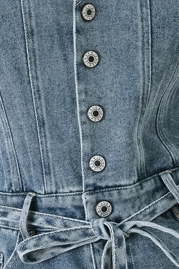 A washed denim romper featuring V neckline, sleeveless, front button/zipper closure, pockets and skinny waist tie