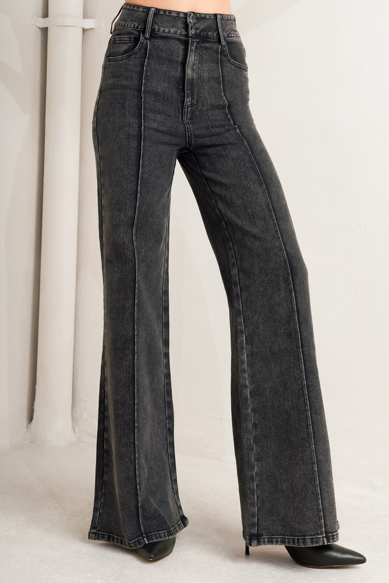 A washed denim pant featuring front closure, pockets, center leg seam and straight leg.