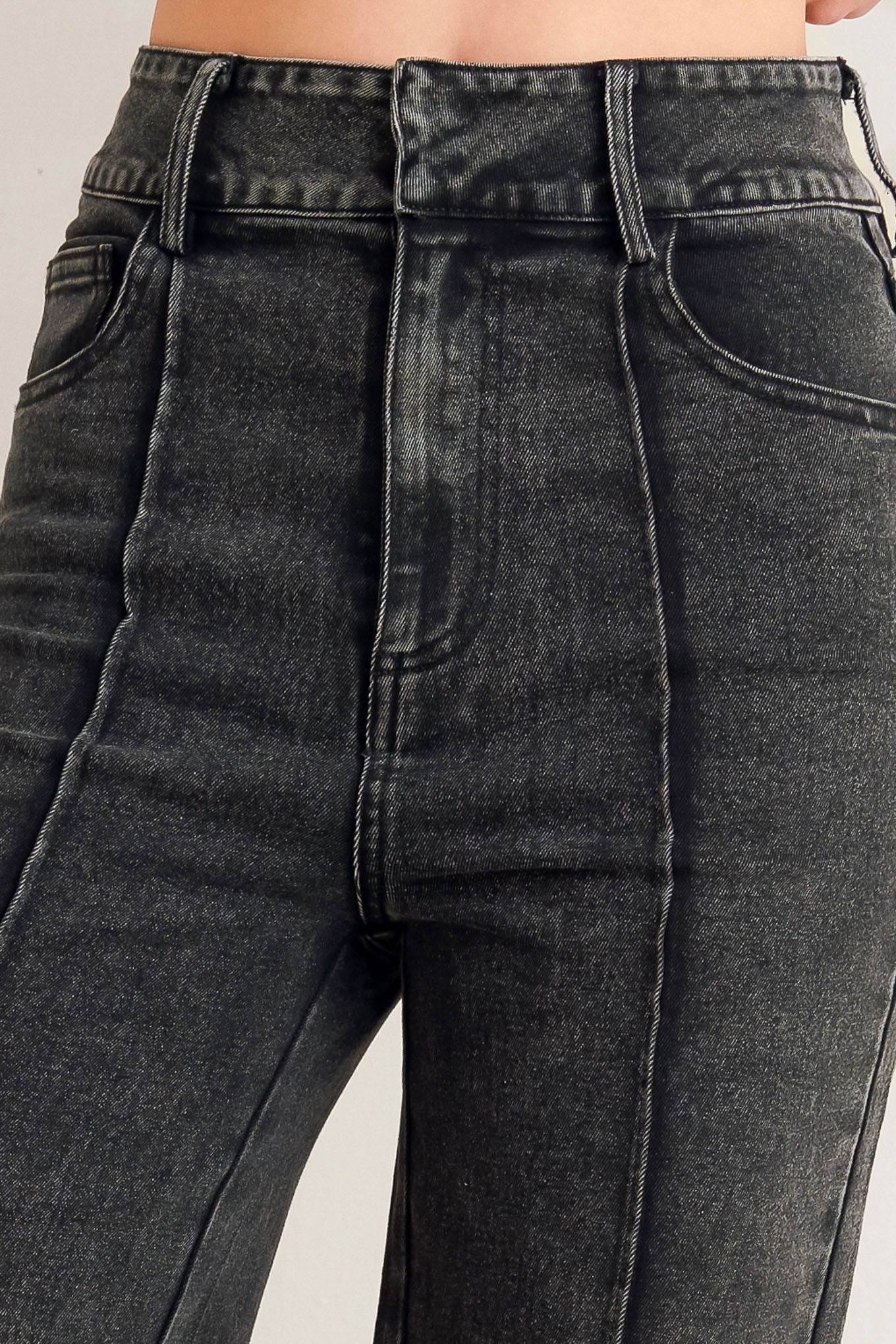 A washed denim pant featuring front closure, pockets, center leg seam and straight leg.