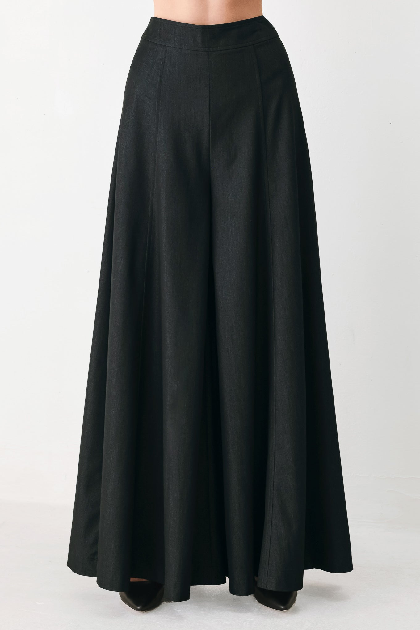 A model wearing high-waisted, wide-leg black trousers | FREEMARKET