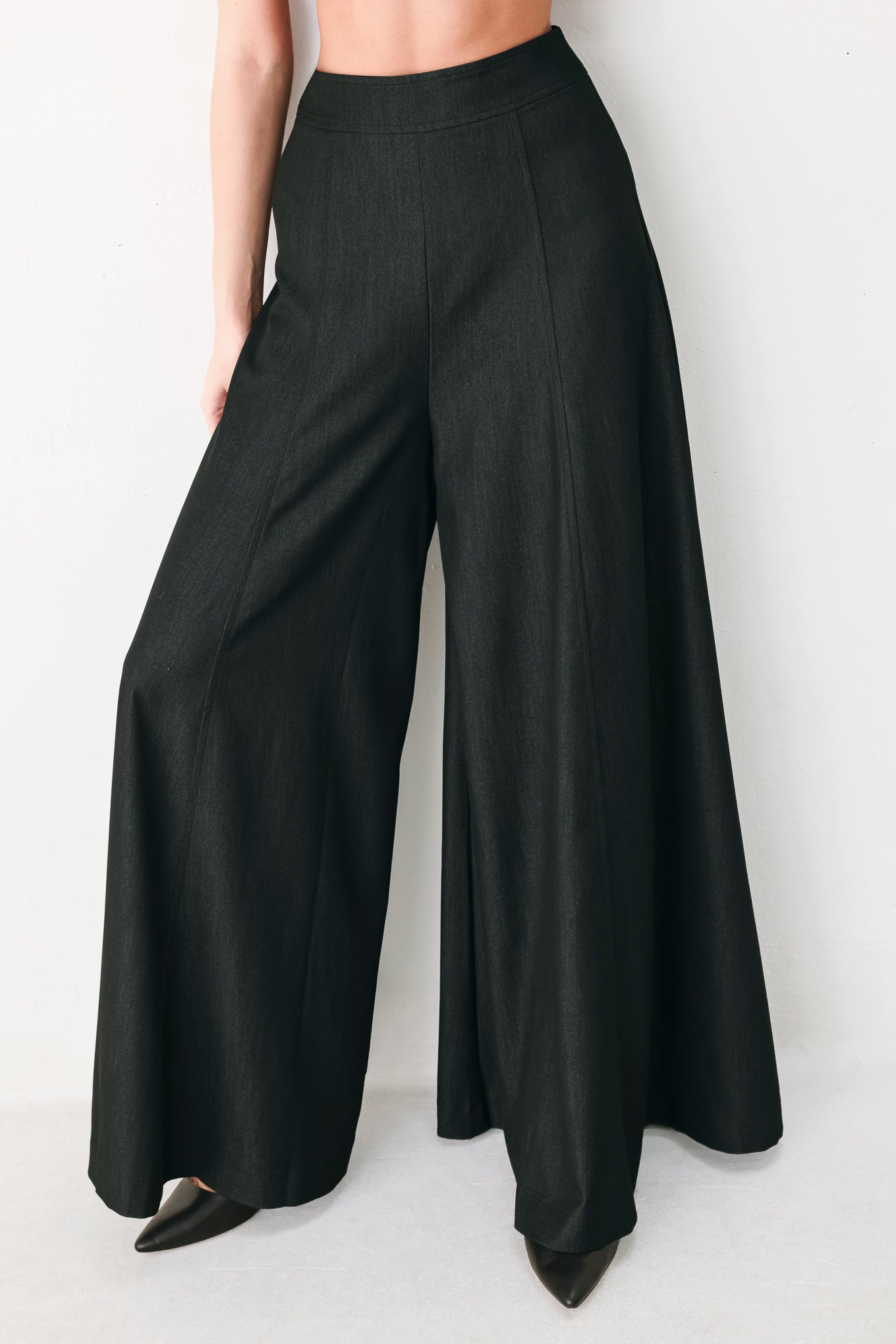 A model wearing high-waisted, wide-leg black trousers | FREEMARKET
