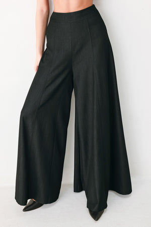 A model wearing high-waisted, wide-leg black trousers | FREEMARKET
