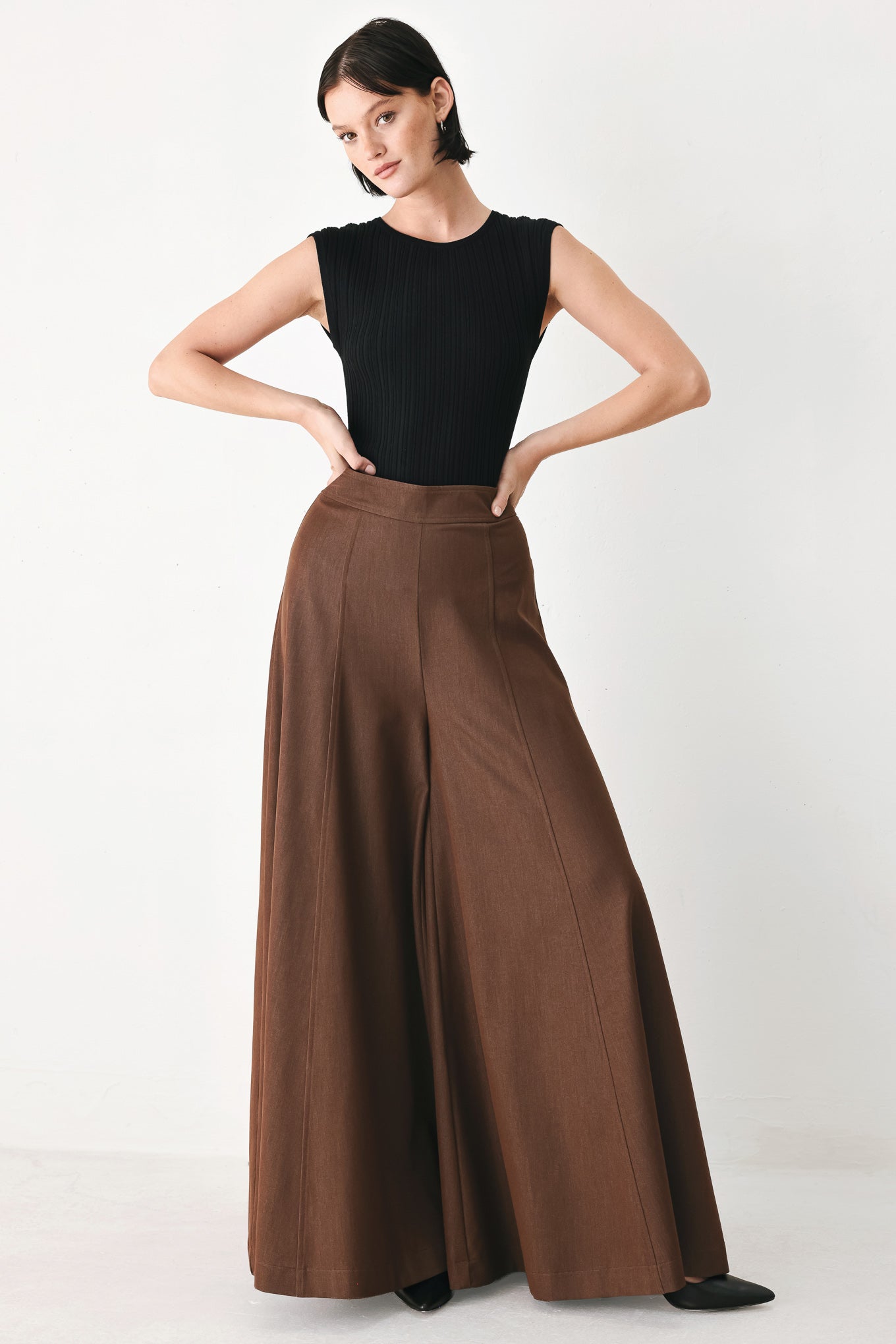 A model wearing high-waisted, wide-leg brown trousers | FREEMARKET