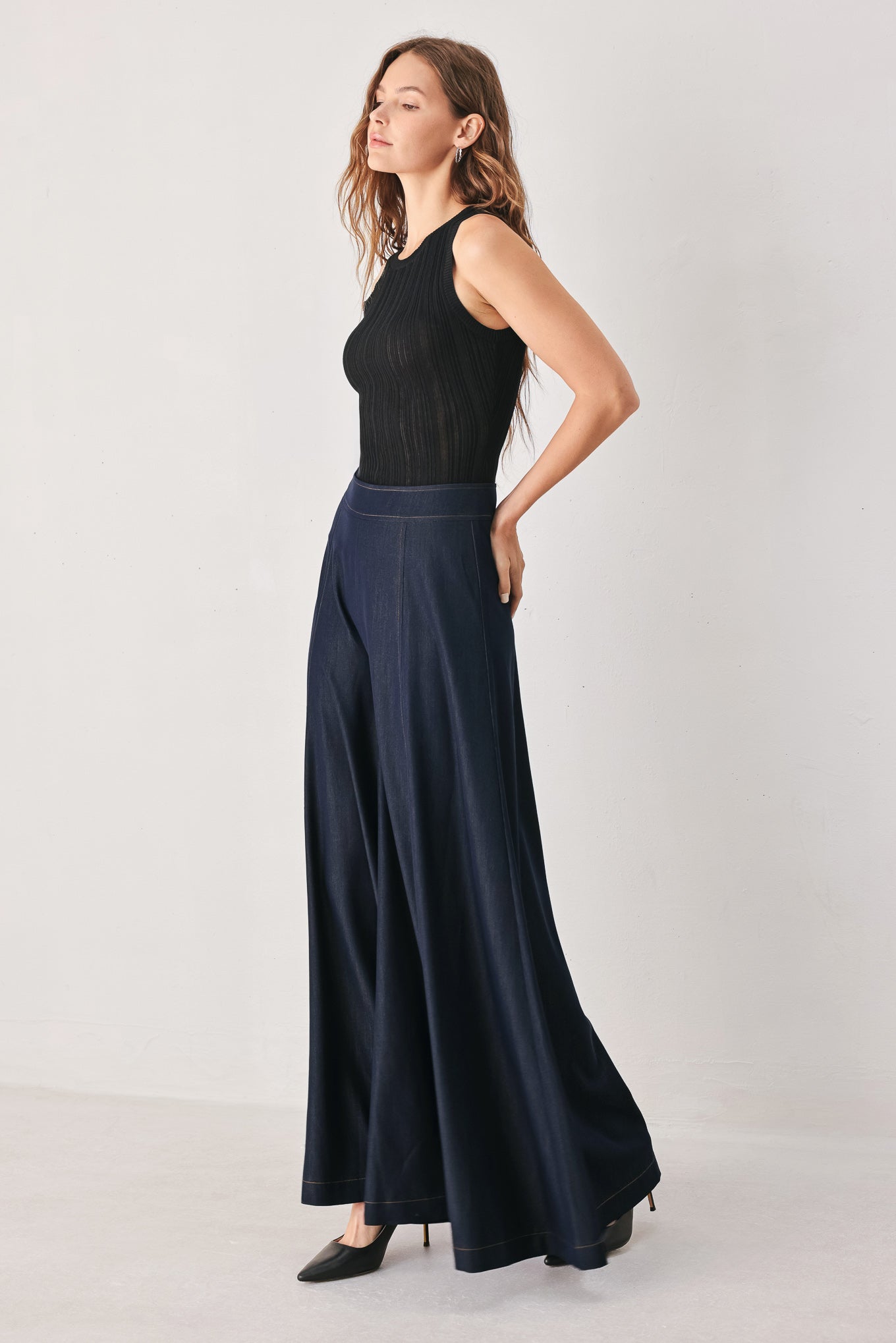 A model wearing high-waisted, wide-leg dark navy blue trousers | FREEMARKET