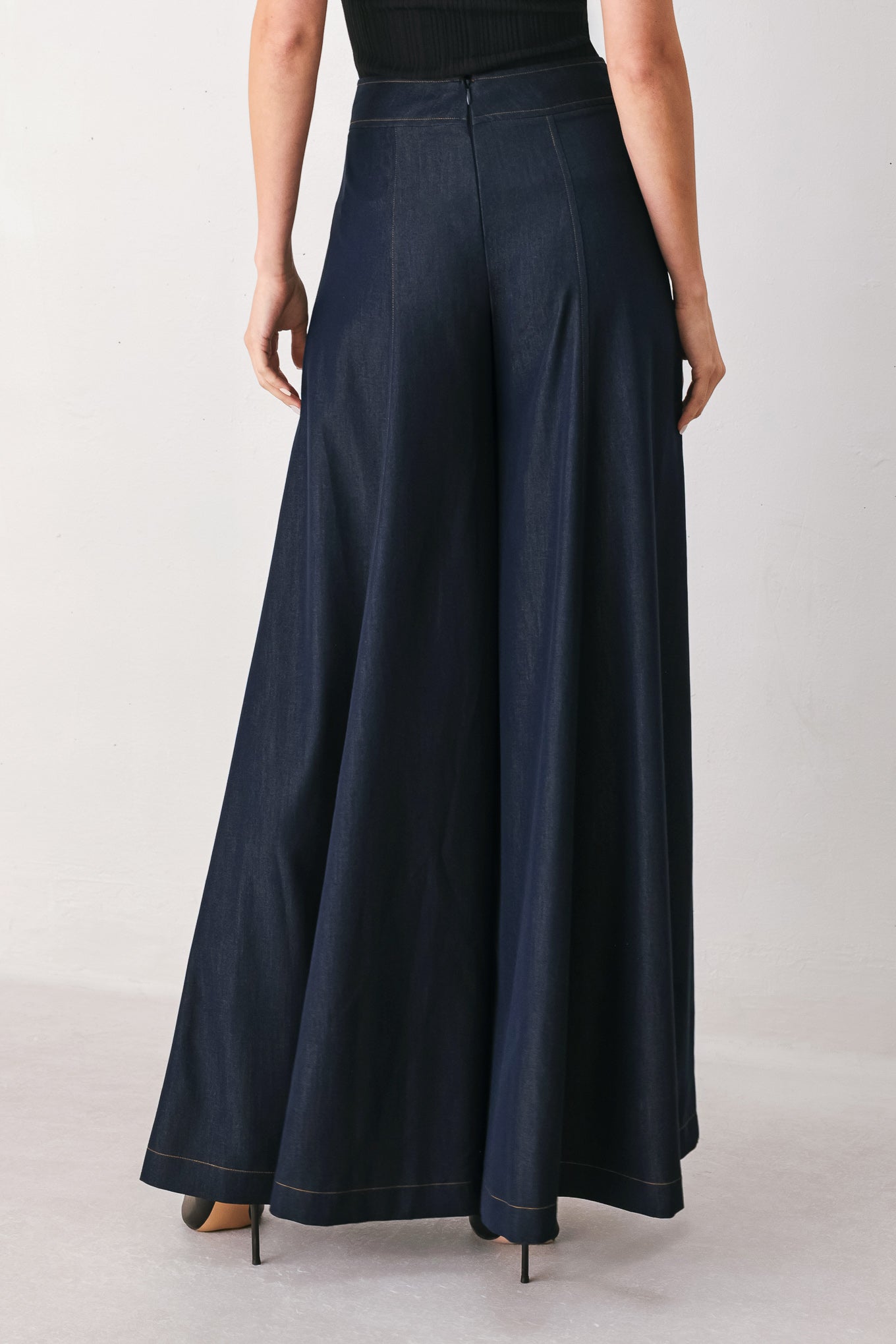 A model wearing high-waisted, wide-leg dark navy blue trousers | FREEMARKET