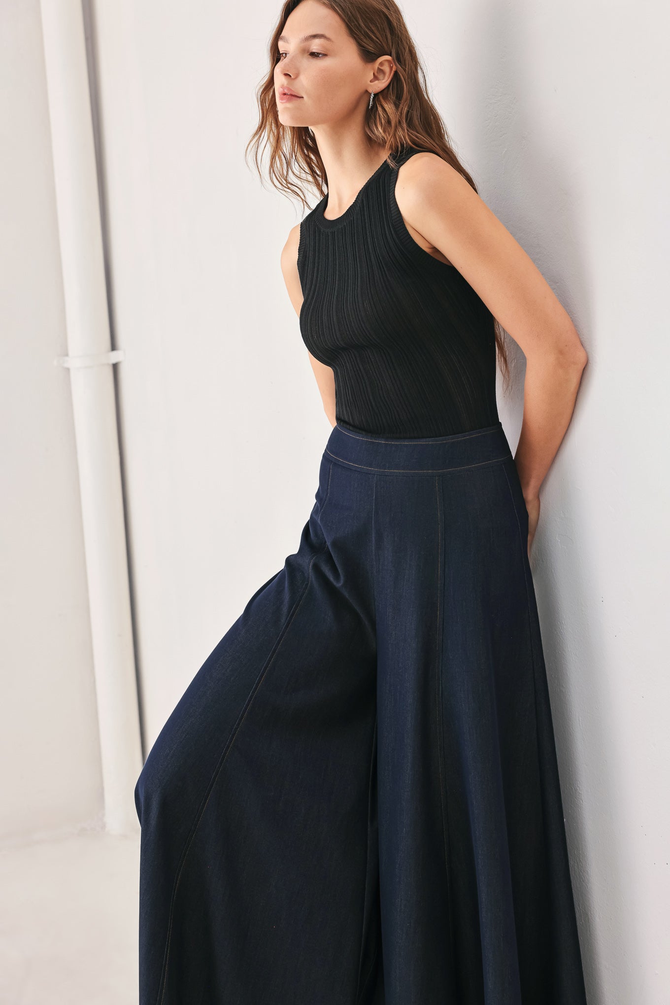 A model wearing high-waisted, wide-leg dark navy blue trousers | FREEMARKET