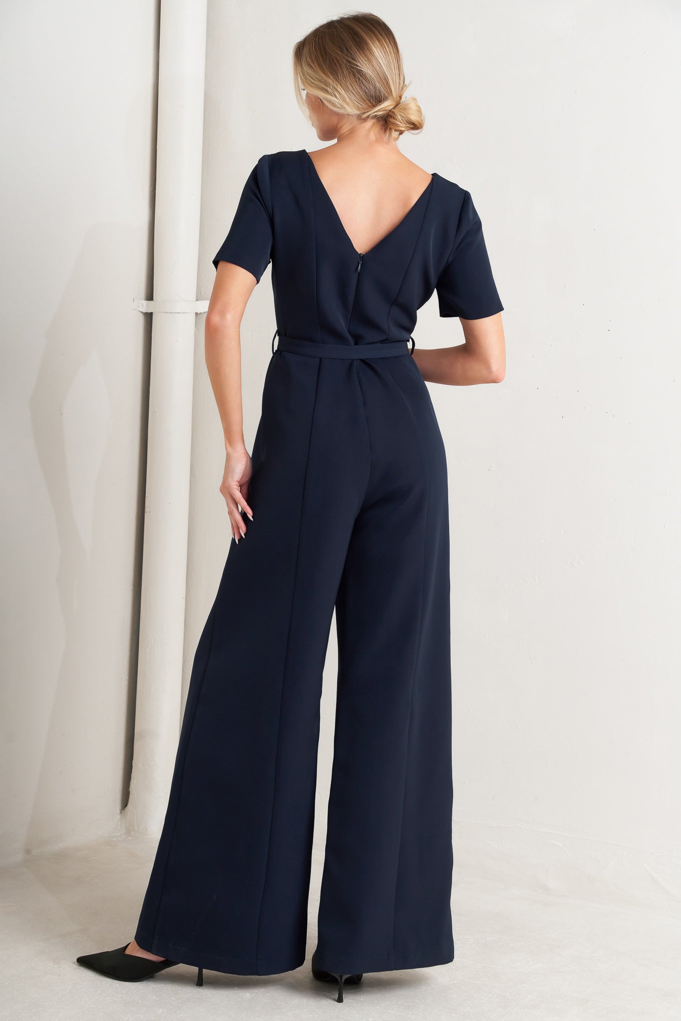 
A solid woven jumpsuit featuring wide neckline, short sleeve, self belt, wide leg, V back and zipper closure

Self : 95% Polyester 5% Spandex

Size &amp; Fit

- Model is 5`8" And Wearing Size Small
- Measurements Taken From Size Small
- Approx. Length: 60"