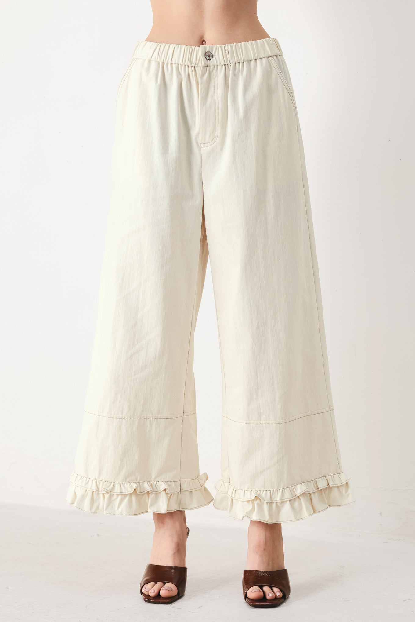 Woman wearing oatmeal culotte pants featuring elastic waist with front closure, side pockets and double ruffle hem | FREEMARKET