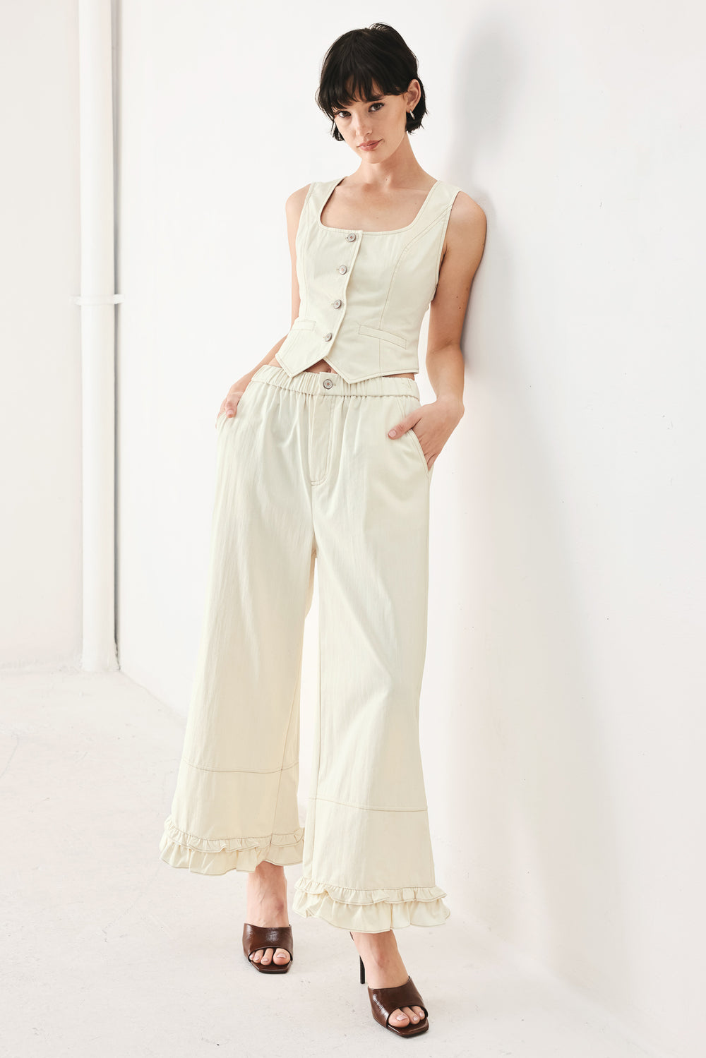 Woman wearing oatmeal culotte pants featuring elastic waist with front closure, side pockets and double ruffle hem | FREEMARKET