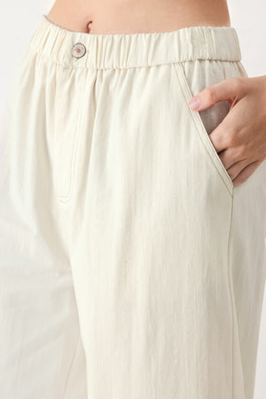 Woman wearing oatmeal culotte pants featuring elastic waist with front closure, side pockets and double ruffle hem | FREEMARKET