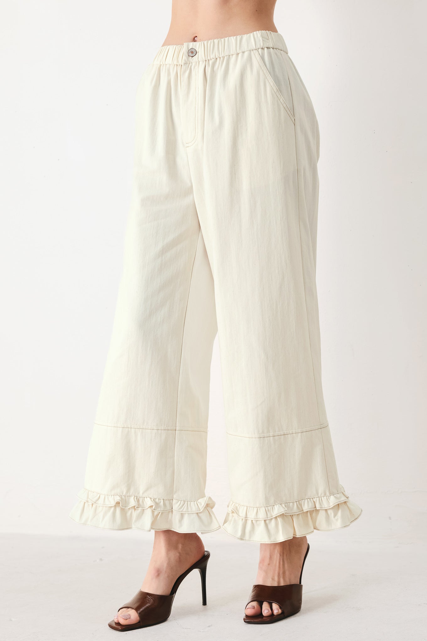 Woman wearing oatmeal culotte pants featuring elastic waist with front closure, side pockets and double ruffle hem | FREEMARKET