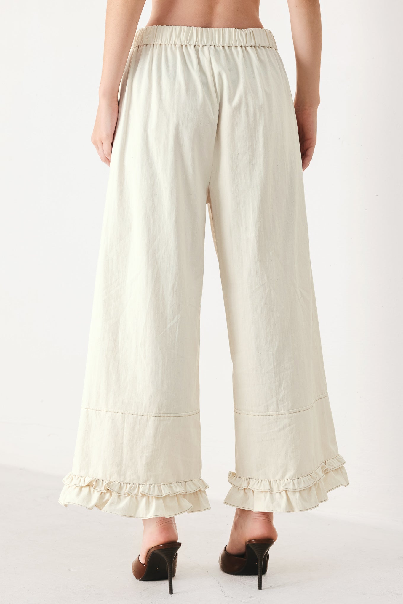 Woman wearing oatmeal culotte pants featuring elastic waist with front closure, side pockets and double ruffle hem | FREEMARKET