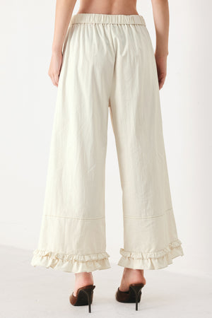 Woman wearing oatmeal culotte pants featuring elastic waist with front closure, side pockets and double ruffle hem | FREEMARKET