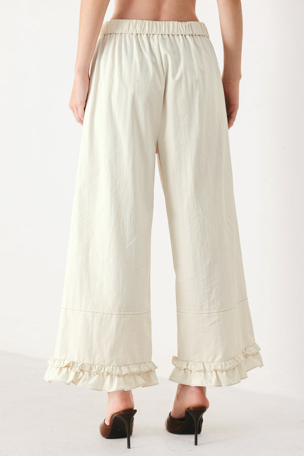 Woman wearing oatmeal culotte pants featuring elastic waist with front closure, side pockets and double ruffle hem | FREEMARKET