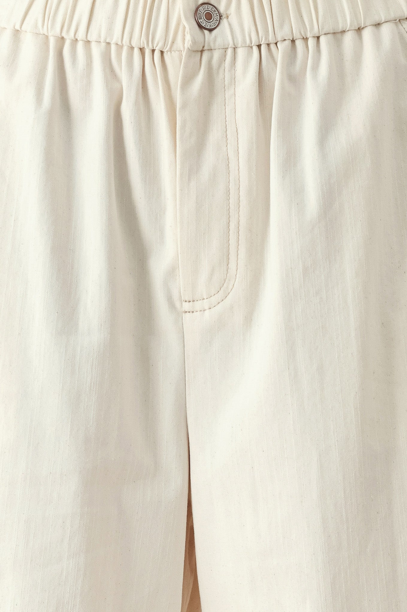 Close up of oatmeal culotte pants featuring elastic waist with front closure, side pockets and double ruffle hem | FREEMARKET