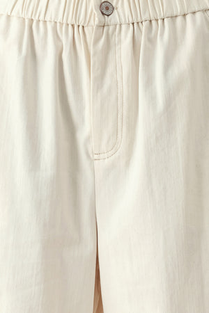 Close up of oatmeal culotte pants featuring elastic waist with front closure, side pockets and double ruffle hem | FREEMARKET
