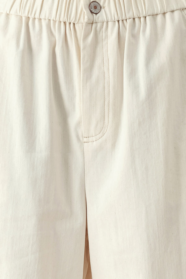 Close up of oatmeal culotte pants featuring elastic waist with front closure, side pockets and double ruffle hem | FREEMARKET