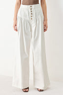 Woman wearing white solid woven pant with elastic waist band, front button closure, pintuck detail and wide leg | FREEMARKET