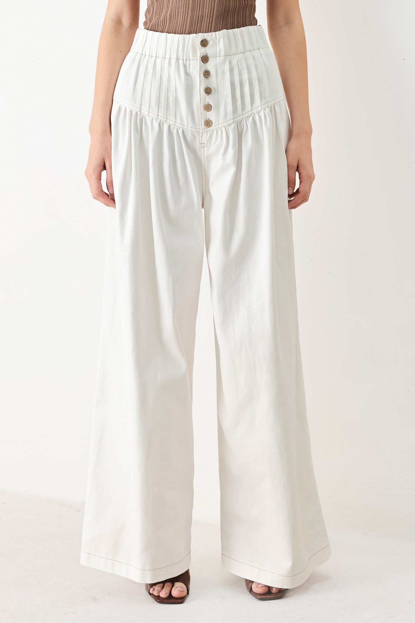 Woman wearing white solid woven pant with elastic waist band, front button closure, pintuck detail and wide leg | FREEMARKET