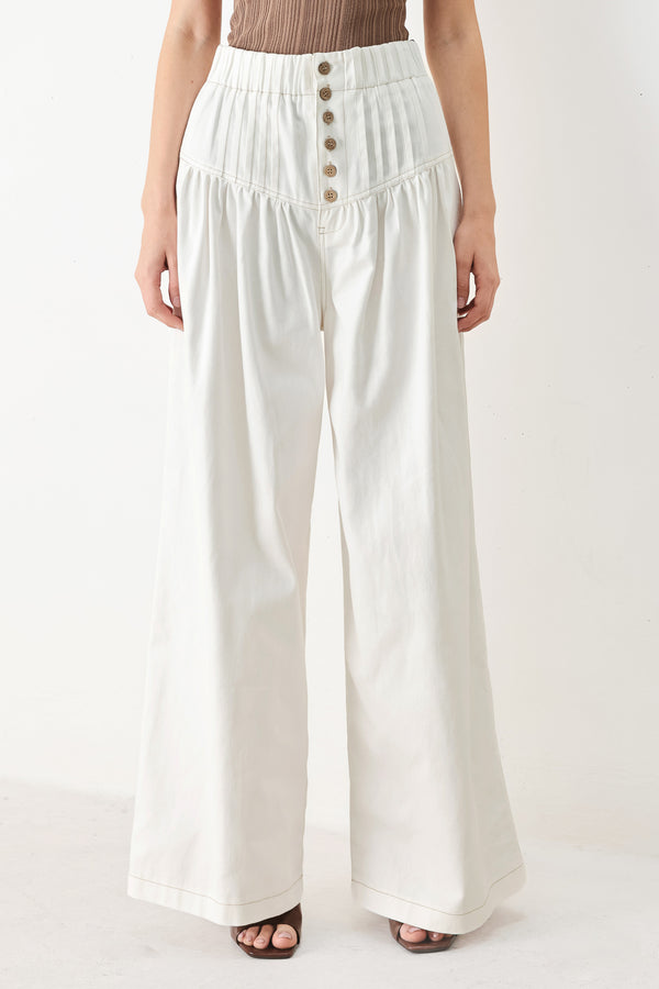Woman wearing white solid woven pant with elastic waist band, front button closure, pintuck detail and wide leg | FREEMARKET