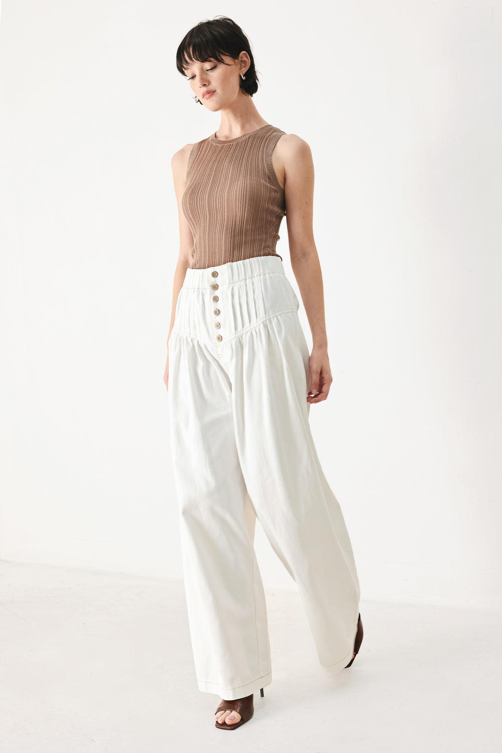Woman wearing white solid woven pant with elastic waist band, front button closure, pintuck detail and wide leg | FREEMARKET