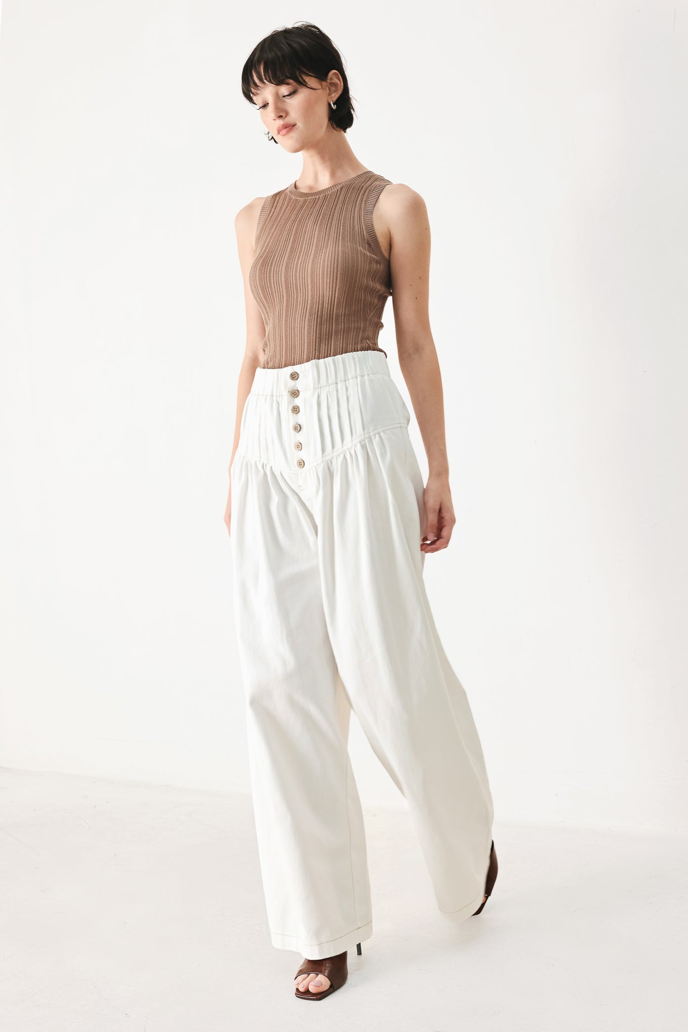 Woman wearing white solid woven pant with elastic waist band, front button closure, pintuck detail and wide leg | FREEMARKET