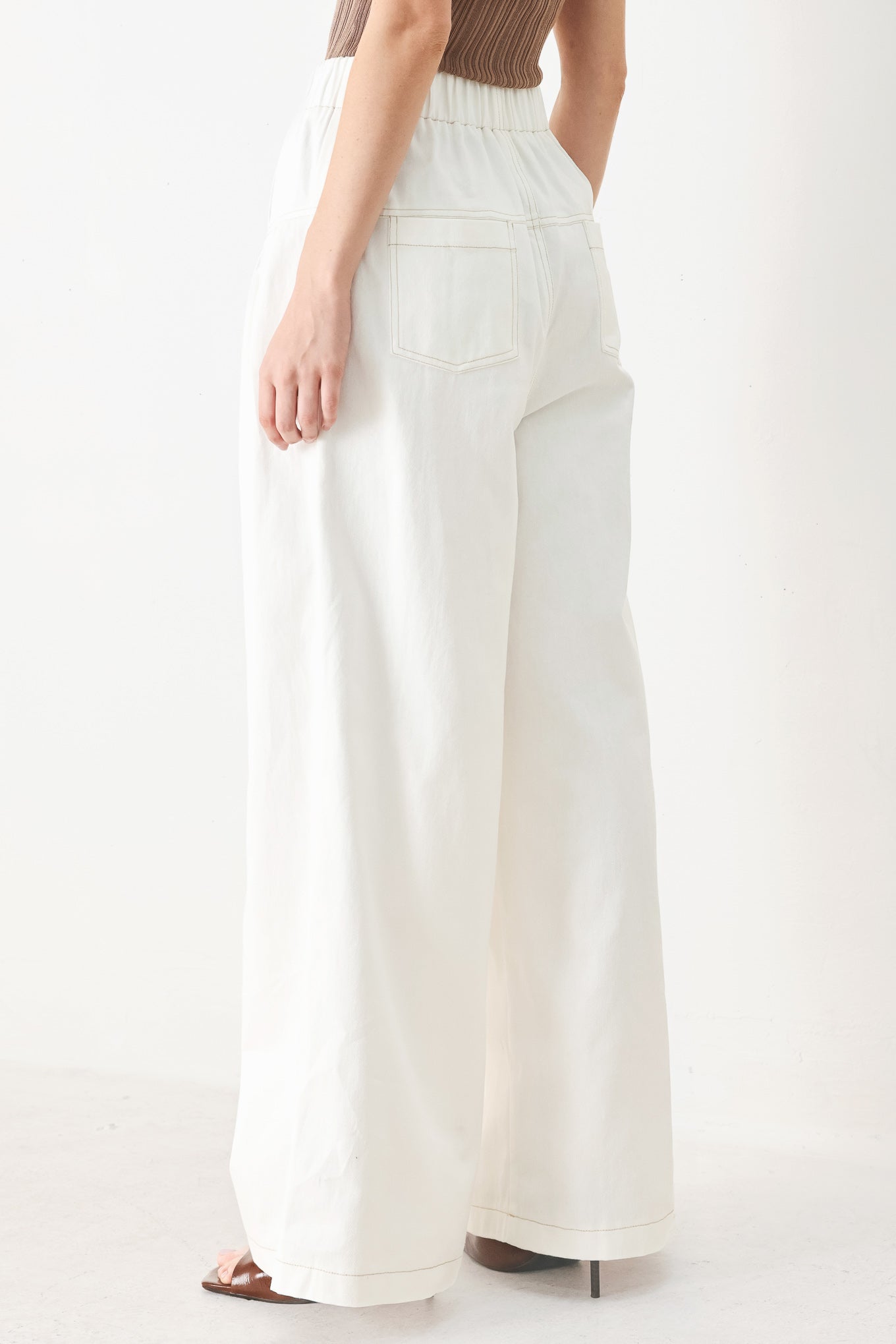 Woman wearing white solid woven pant with elastic waist band, front button closure, pintuck detail and wide leg | FREEMARKET