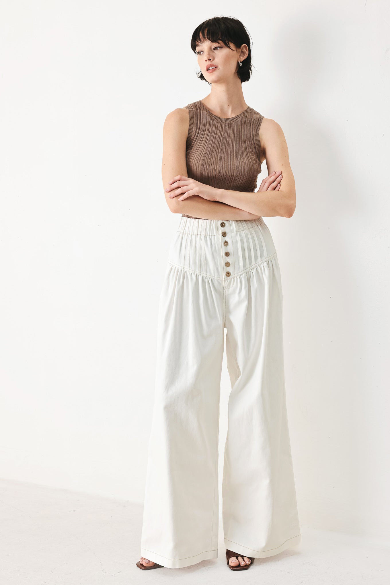 Woman wearing white solid woven pant with elastic waist band, front button closure, pintuck detail and wide leg | FREEMARKET