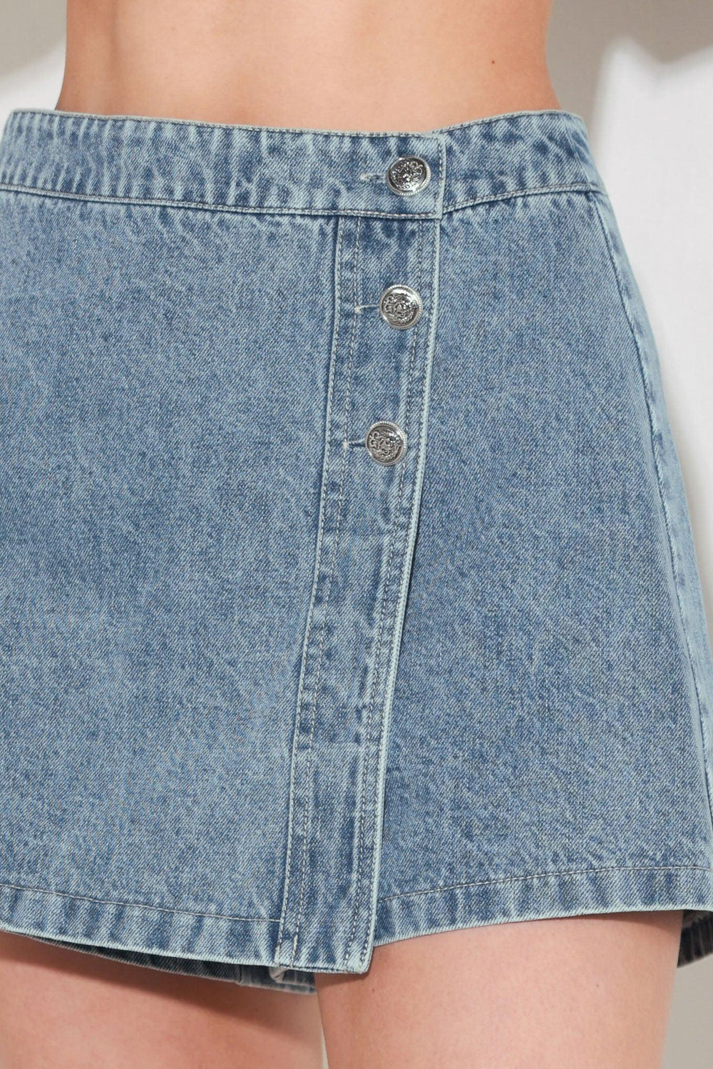
A washed denim skort featuring side button and front zipper closure. Matching jacket FJ1400B

Details:

Self : 100% Cotton

Size &amp; Fit

- Model is 5`8" And Wearing Size Small
- Measurements Taken From Size Small
- Approx. Length: 15"