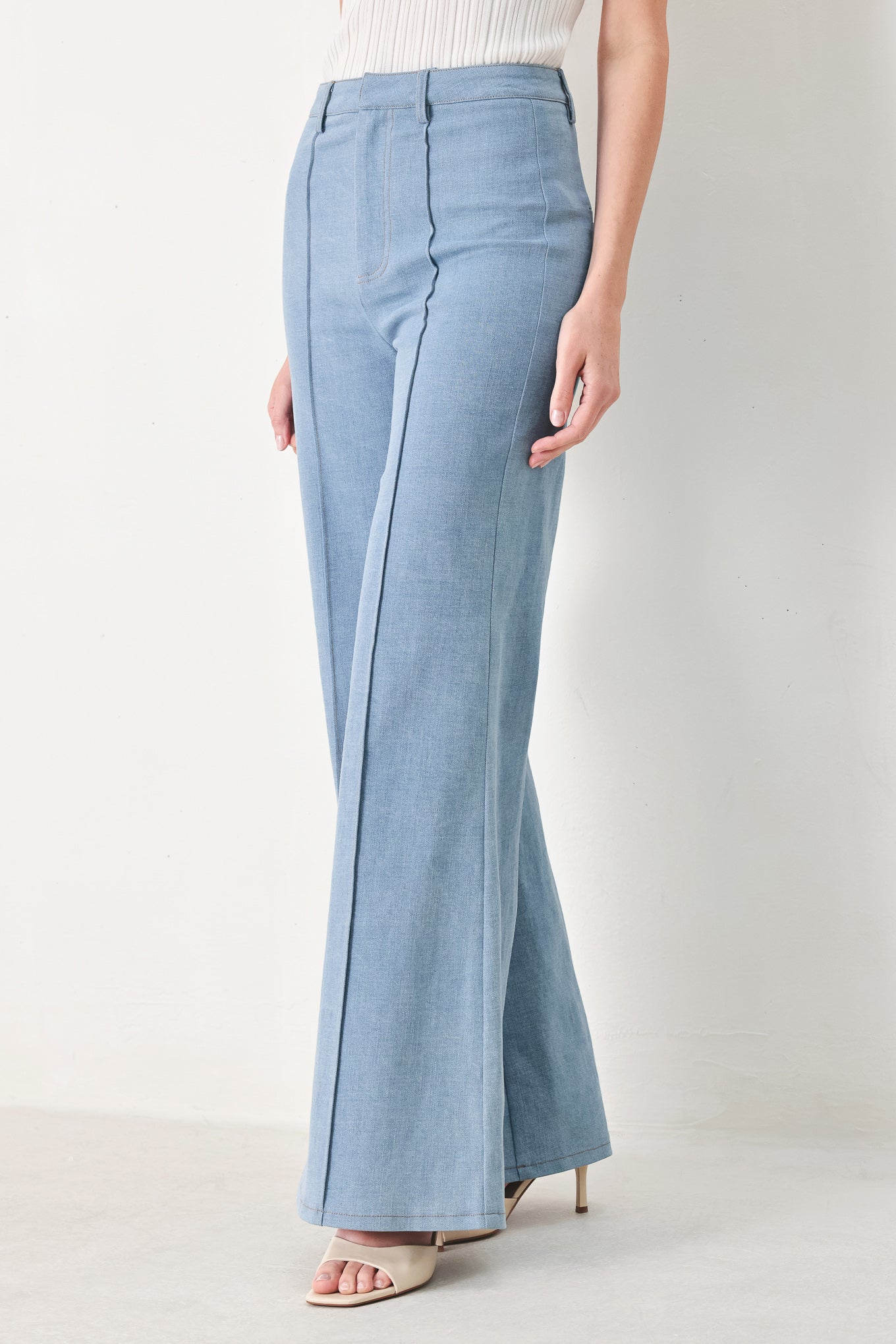 Woman wearing light blue boot cut pants with front closure | FREEMARKET | Flying Tomato