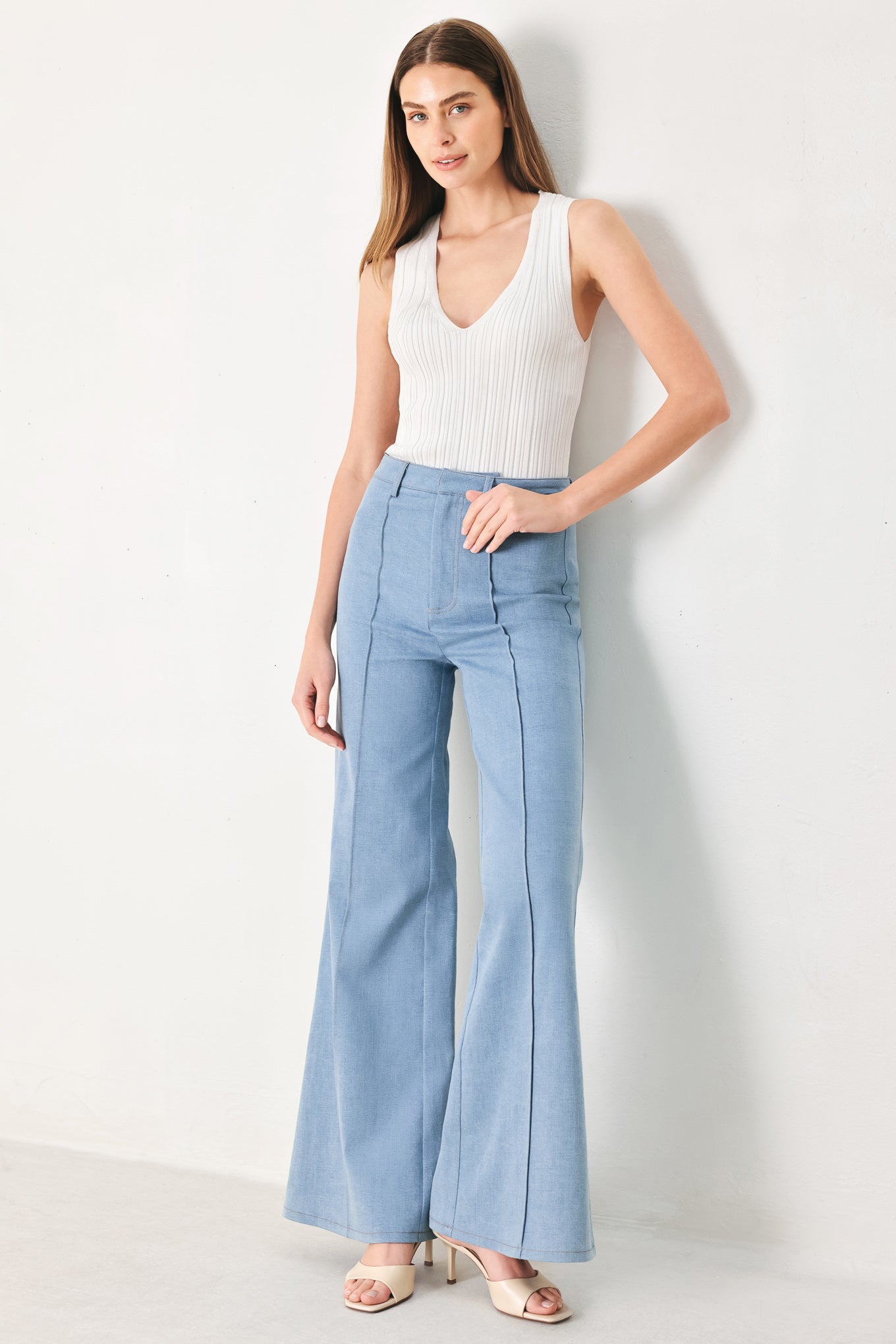 Woman wearing light blue boot cut pants with front closure | FREEMARKET | Flying Tomato