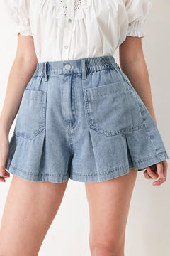 Woman wearing washed light denim short featuring elastic waist, front closure, front pockets and pleats with wide leg | FREEMARKET