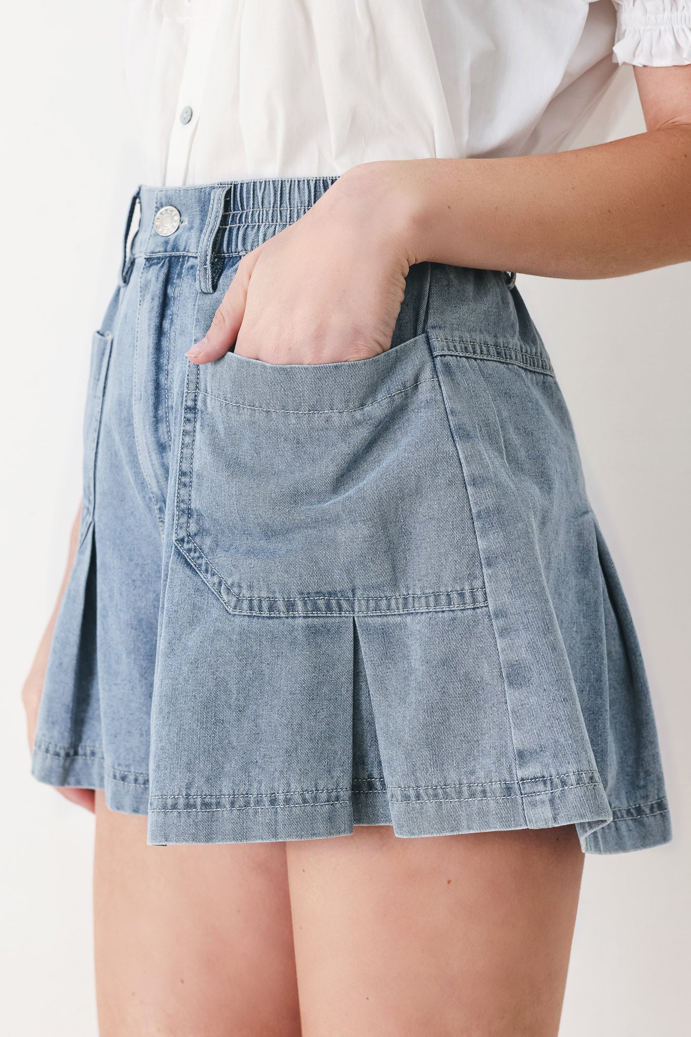 Woman wearing washed light denim short featuring elastic waist, front closure, front pockets and pleats with wide leg | FREEMARKET