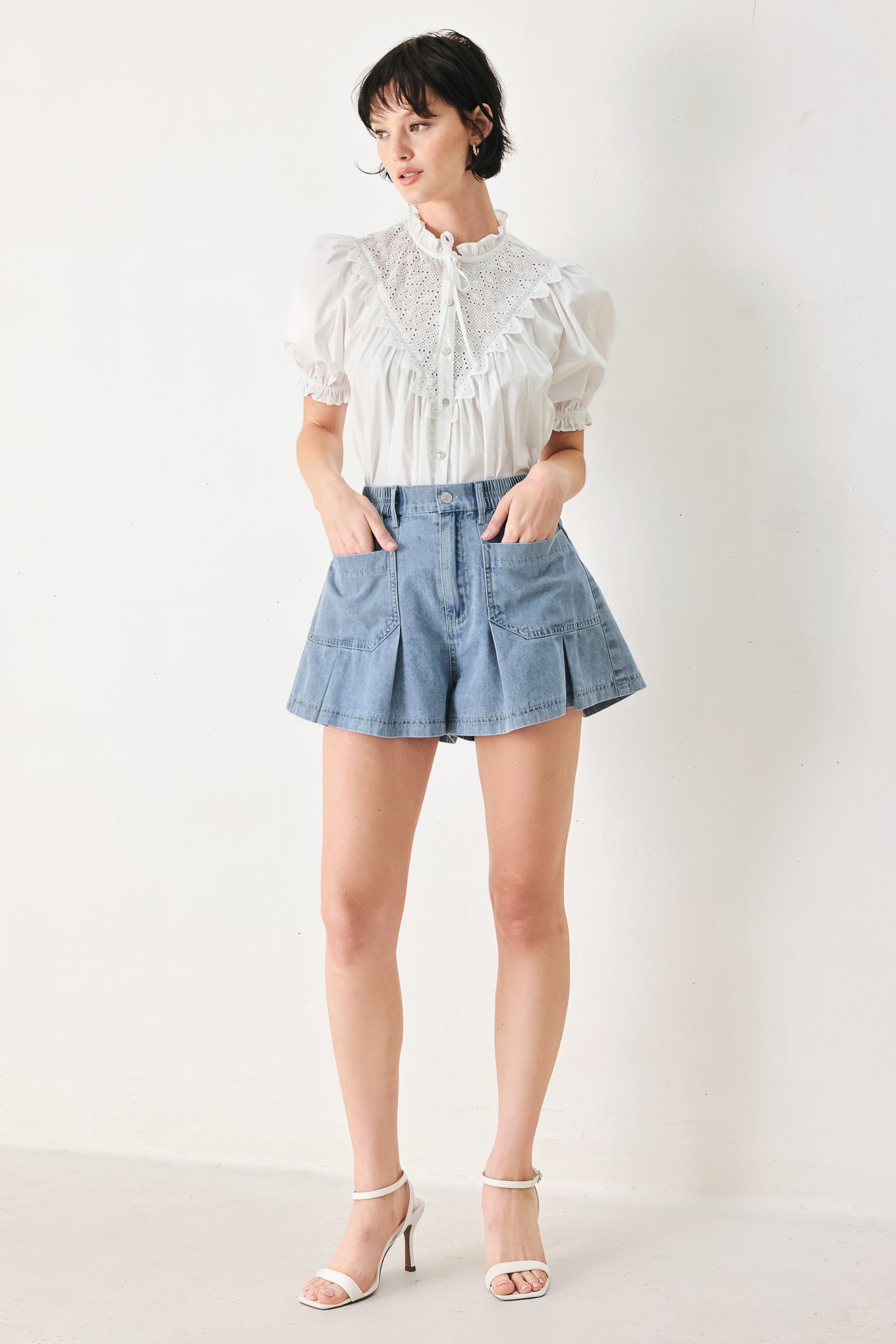 Woman wearing washed light denim short featuring elastic waist, front closure, front pockets and pleats with wide leg | FREEMARKET
