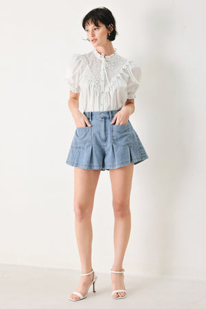 Woman wearing washed light denim short featuring elastic waist, front closure, front pockets and pleats with wide leg | FREEMARKET