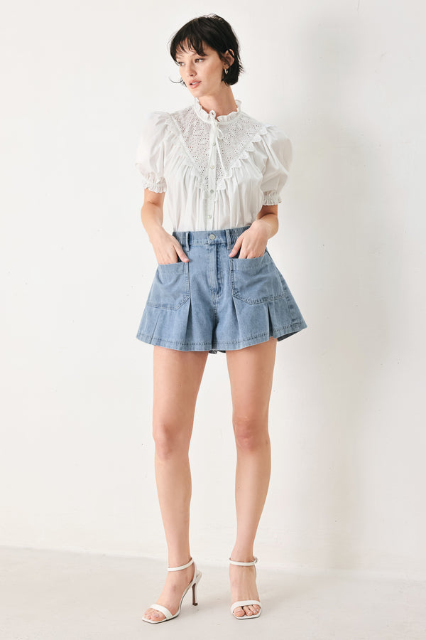 Woman wearing washed light denim short featuring elastic waist, front closure, front pockets and pleats with wide leg | FREEMARKET