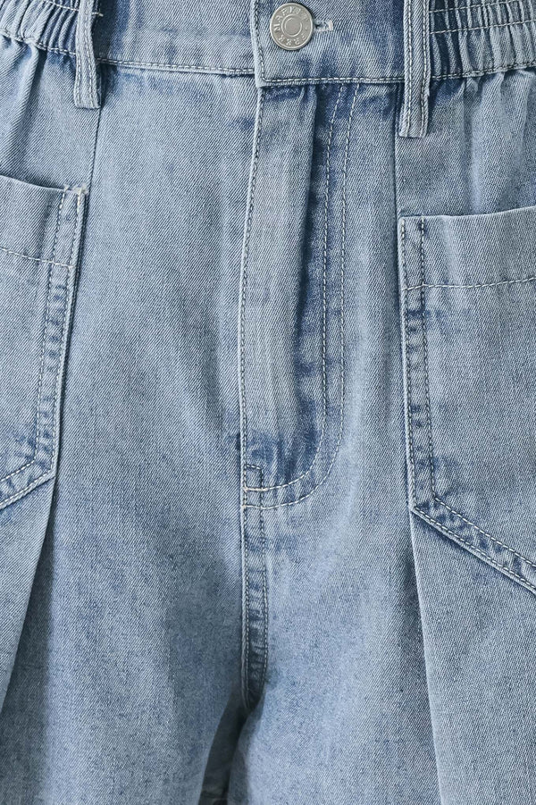 Close up of a washed light denim short featuring elastic waist, front closure, front pockets and pleats with wide leg | FREEMARKET