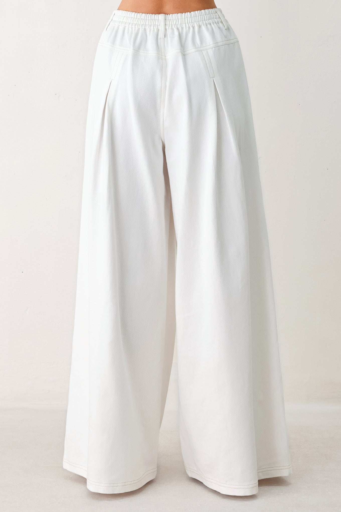 Woman wearing white wide-leg pants | FREEMARKET