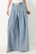 Woman wearing a light blue denim wide-leg pants with a drawstring waist | FREEMARKET